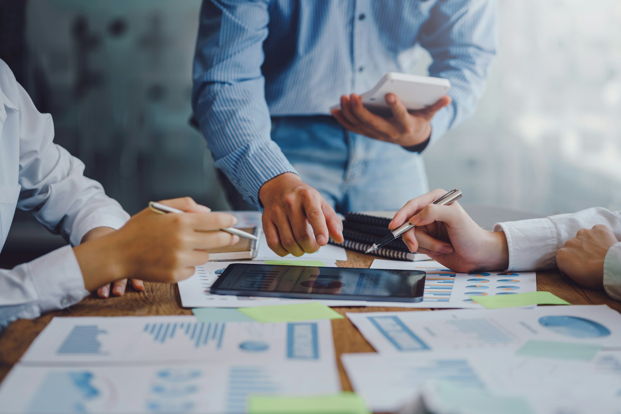 Business people pointing to a graph to analyze market data